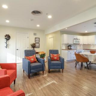 A modern open-space living room and kitchen area with stylish furniture and wood flooring.