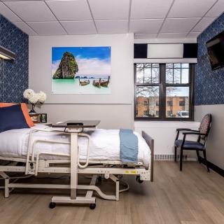 A well-decorated hospital room with a bed and modern furnishings.