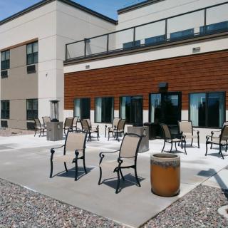 A modern outdoor patio area with chairs and tables on a sunny day.