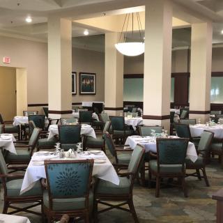 An empty restaurant dining room with neatly arranged tables and chairs.