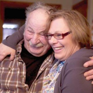 A happy couple sharing a warm embrace indoors.