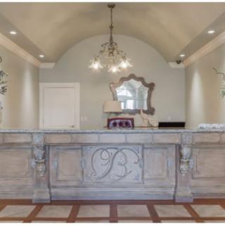 An elegantly designed reception area featuring a decorative desk and chandelier.
