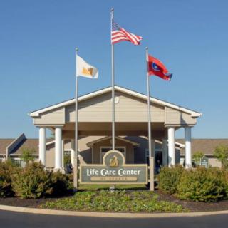 Entrance of a care center with flags displayed above.