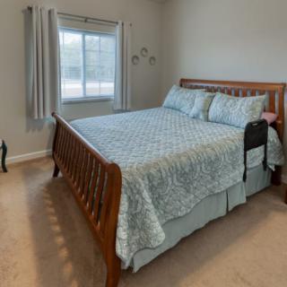 A cozy bedroom with a large wooden bed and soft bedding.
