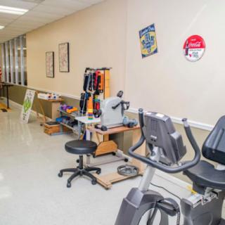 A fitness area featuring stationary exercise bikes and various workout equipment in a well-lit indoor setting.