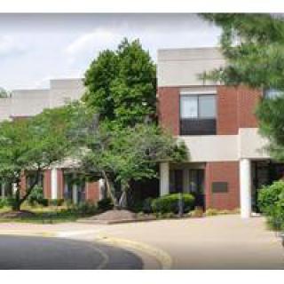 An exterior view of a building surrounded by trees and well-maintained landscaping.