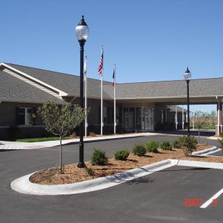 Exterior view of a building with landscaped surroundings and flags on display.