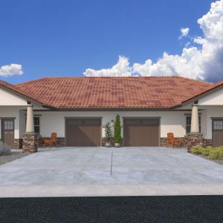A modern duplex with a shared driveway and two garages under a clear blue sky.