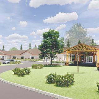 A suburban neighborhood with landscaped lawns and houses under a clear blue sky.