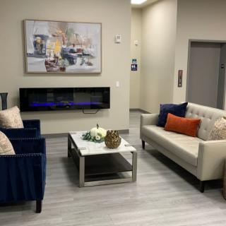 A modern living room with stylish furniture and a wall-mounted fireplace.