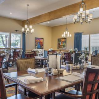 Cozy dining area with neatly arranged tables and elegant chandeliers.