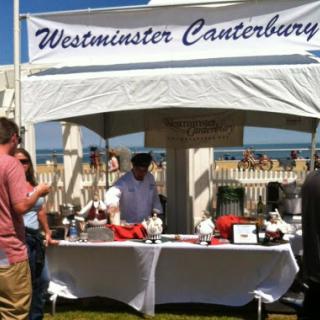 A bustling outdoor booth for Westminster Canterbury, showcasing a variety of offerings at an event.