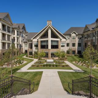 A modern apartment complex with landscaped courtyard and pathways.