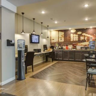 A modern cafe interior with seating, computers, and a water cooler.
