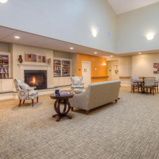A cozy lobby area featuring a fireplace, comfortable seating, and soft lighting.