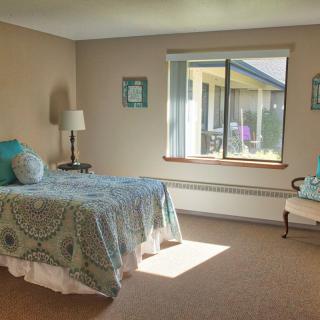 A cozy bedroom with a single bed, window, and simple decor.