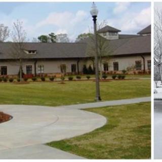 A scenic view of a building surrounded by a landscaped park with a winding pathway and lamp post.