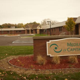 A view of the entrance to a medical facility, featuring a sign indicating its name.