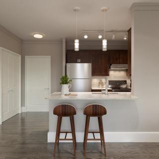 A modern kitchen with sleek design elements, featuring a stainless steel refrigerator and contemporary bar stools.