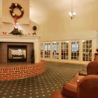 A cozy living room with a decorated fireplace and holiday wreath.