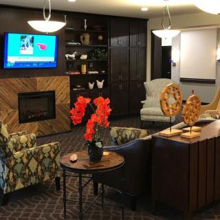 A modern living room with comfortable seating, a fireplace, and decor elements.