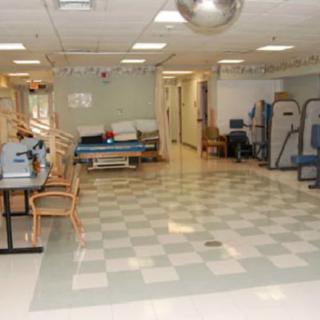 A spacious rehabilitation room equipped for physical therapy and treatment.