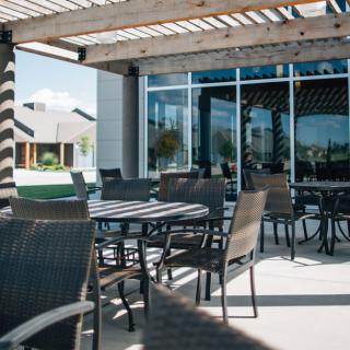 A sunny outdoor patio with tables and chairs, perfect for dining.