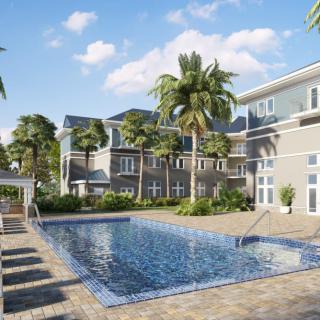 A serene residential area with a swimming pool surrounded by palm trees on a sunny day.