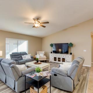 A modern living room with gray sofas, a large TV, and stylish decor.