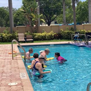 Friends enjoying a fun fitness session in the pool.