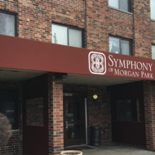 Entrance of the Symphony of Morgan Park building, featuring a brick facade and prominent signage.