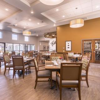 A spacious and elegantly decorated dining area with neatly arranged tables and chairs.