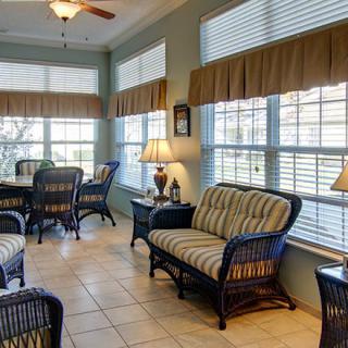 A cozy sunroom with wicker furniture and ample natural light.
