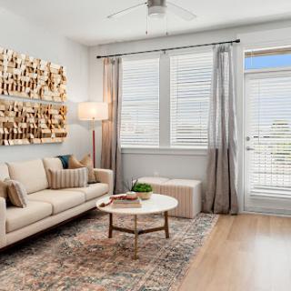 A stylish and inviting living room featuring a beige sofa, modern coffee table, and natural light streaming through the windows.
