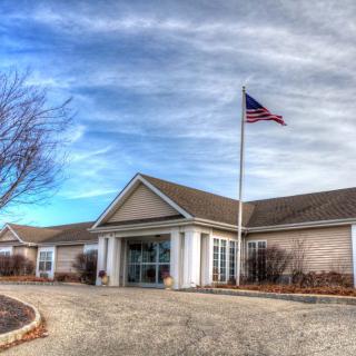 A building with an American flag flying outside under a cloudy sky.