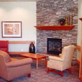 A cozy living room with a stone fireplace and comfortable seating.