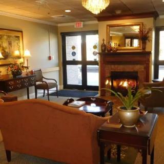 A cozy lobby featuring a seating area with a fireplace and elegant decor.