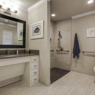 A modern bathroom with a large mirror, sleek vanity, and a walk-in shower.