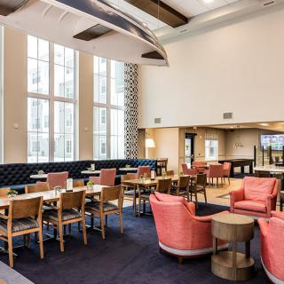 A modern lounge area with comfortable seating and large windows.