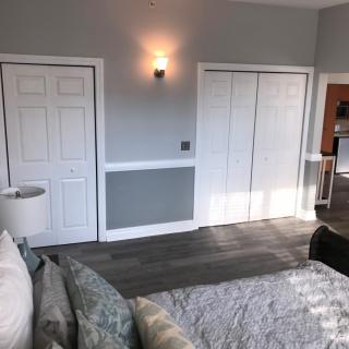 A modern bedroom with grey walls, white doors, and stylish lighting.