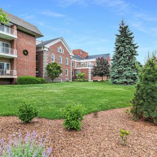 A serene residential area featuring a well-maintained lawn and lush greenery.