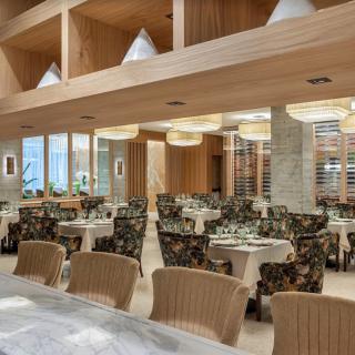 A modern restaurant interior featuring neatly arranged dining tables and chairs.