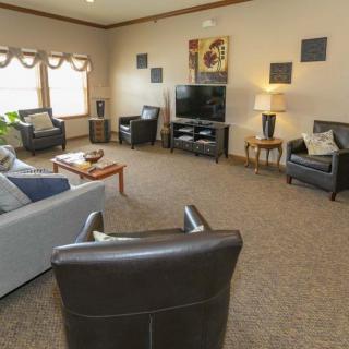 A cozy living room with comfortable seating and a large TV.