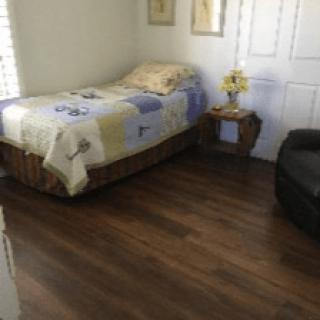 A cozy bedroom with a single bed and wooden flooring.