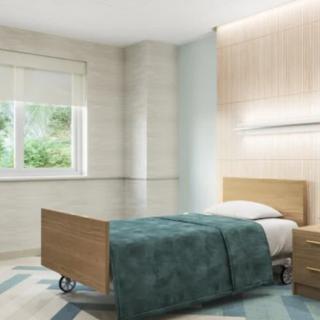 A minimalist hospital room with a single wooden bed and natural lighting.