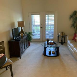 A cozy living room with a sofa, coffee table, and TV, featuring homey decor.