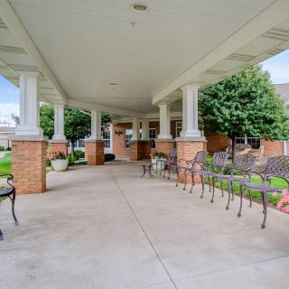 A covered outdoor area with benches leading to a building entrance.