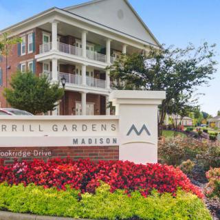 Entrance to a residential apartment complex with vibrant landscaping.