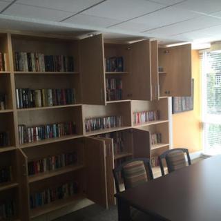 A cozy library space featuring organized bookshelves and a study table.