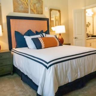 A well-decorated bedroom with a neatly made bed and stylish lamps.